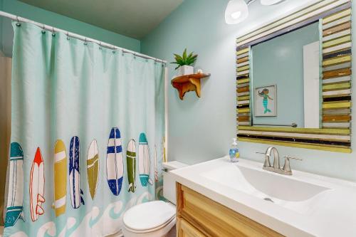 a bathroom with a shower curtain with surfboards on it at Spencer's Watch in Avon