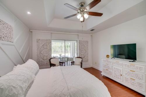 a bedroom with a bed and a tv and a table at Port St Lucie Canal-Front Home with Heated Pool! in Port Saint Lucie