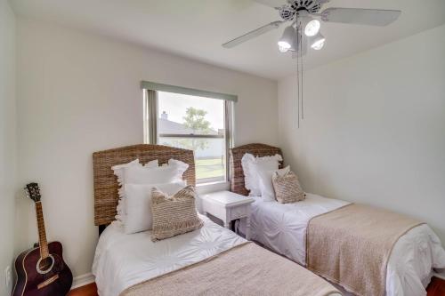Una habitación con 2 camas y una guitarra. en Port St Lucie Canal-Front Home with Private Pool! en Port Saint Lucie