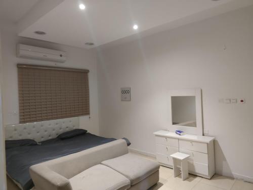 1 dormitorio con cama, tocador y espejo en روز حي الربوه في الرياض en Riad