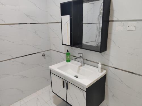 a white bathroom with a sink and a mirror at روز حي الربوه في الرياض in Riyadh