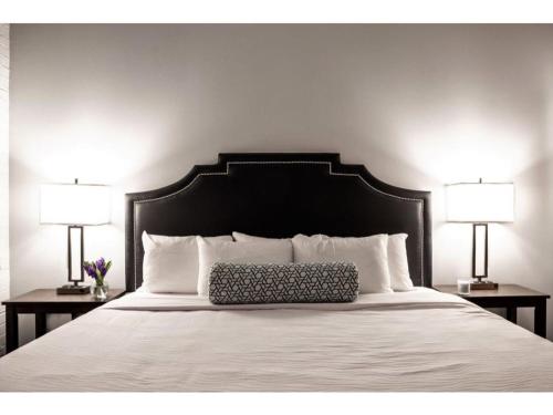 uma cama com uma cabeceira preta e duas lâmpadas em Modern Apartment Close To Everything CozySuites em Indianápolis