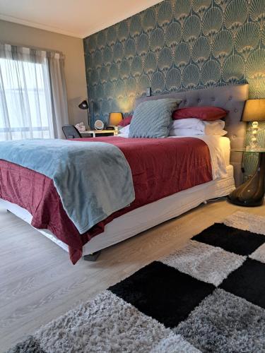 a bedroom with a large bed and a rug at Sunbrae Beach luxury in Mount Maunganui
