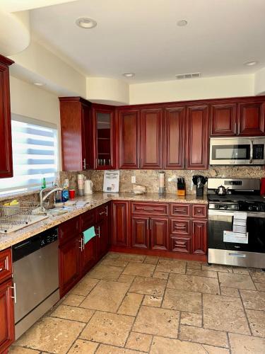 a large kitchen with wooden cabinets and appliances at Qazaq Hostel in Los Angeles