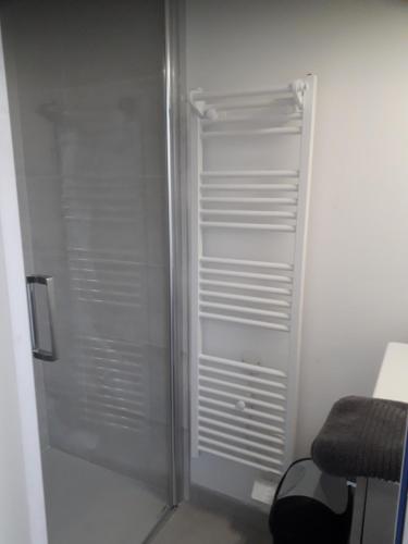 a white refrigerator in a room with a chair at Studio moderne bords de Loire in Juigné-sur-Loire