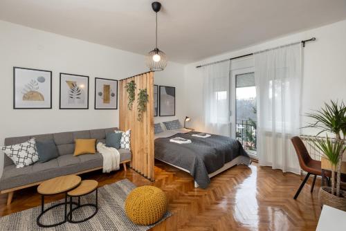 a bedroom with a bed and a couch at Apartman Roza in Zagreb