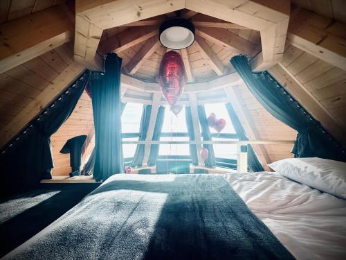 a bedroom with a ceiling with a large window at Heavenly Houses - Niebiańskie Domki in Jaworzynka