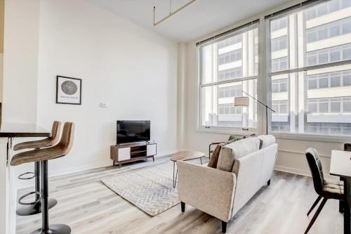 a living room with a couch and a tv at CozySuites - 2BR with Direct Skybridge Access #3 in Indianapolis