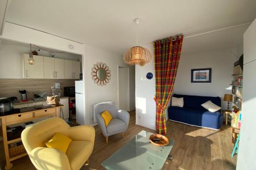 een woonkamer met een bank en een keuken bij Nice studio near the sea in Arcachon