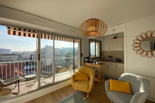 un salon avec deux chaises et une grande fenêtre dans l'établissement Nice studio near the sea, à Arcachon