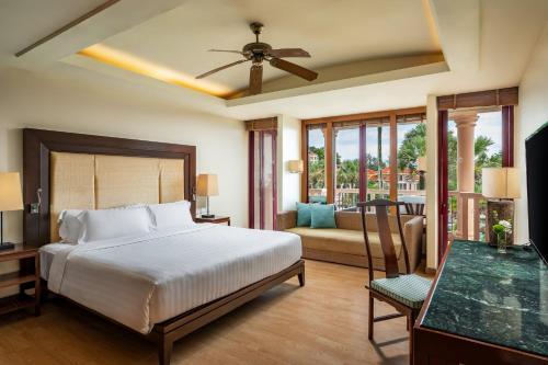 a bedroom with a bed and a living room at Centara Grand Beach Resort Phuket - SHA Plus in Karon Beach