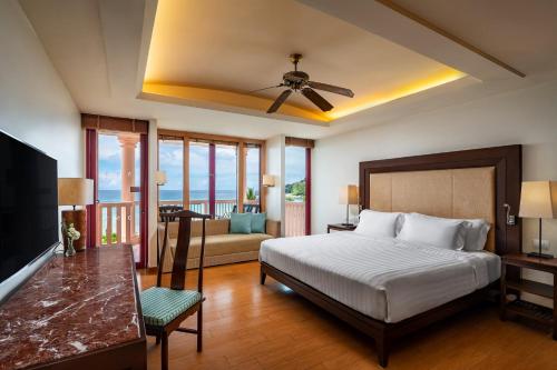 a bedroom with a bed and a living room at Centara Grand Beach Resort Phuket in Karon Beach