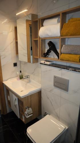a bathroom with a sink and a toilet and towels at Villa Dream Kuşadası Pool- Garage in Kuşadası