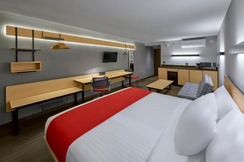 um quarto de hotel com uma cama grande e uma secretária em City Express by Marriott La Paz em La Paz