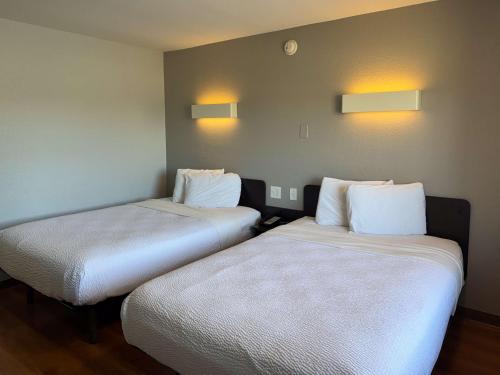two beds in a room with lights on the wall at Motel 6-Simi Valley, CA in Simi Valley