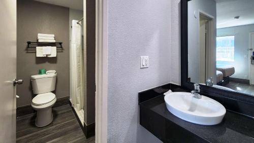 bagno con lavandino, servizi igienici e specchio di Motel 6-Galveston, TX a Galveston