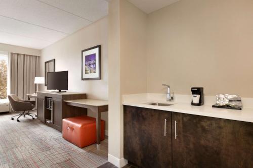 a hotel room with a kitchen with a sink and a desk at Hampton Inn Denville-Rockaway-Parsippany in Denville