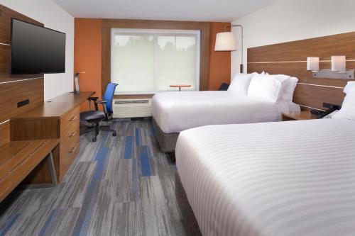 a hotel room with two beds and a flat screen tv at Holiday Inn Express & Suites by IHG Altoona by IHG in Altoona