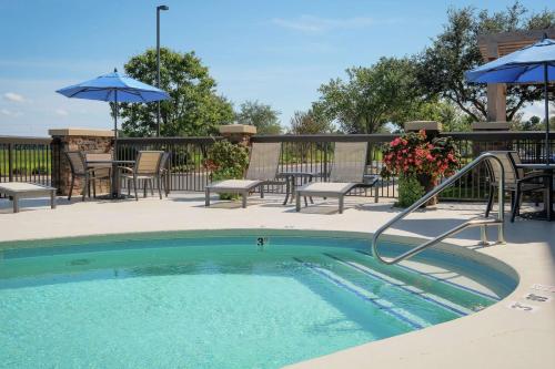 a swimming pool with chairs and umbrellas on a patio at Hampton Inn Edenton in Edenton