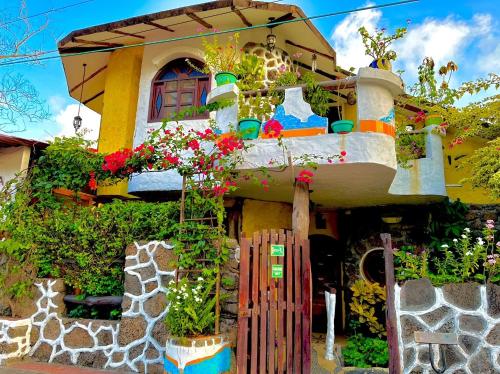 uma casa colorida com flores em frente em Casa del Lago Lodging House em Puerto Ayora