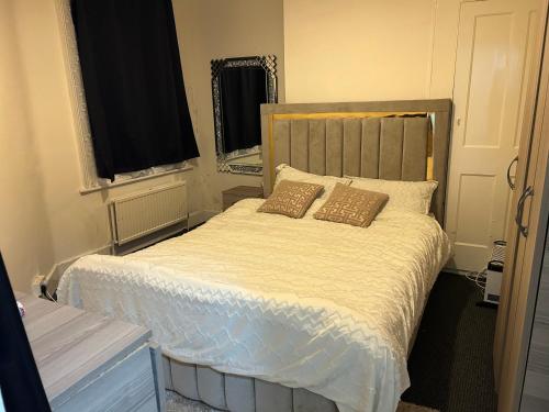 een slaapkamer met een bed met 2 kussens erop bij House with private garden in Londen