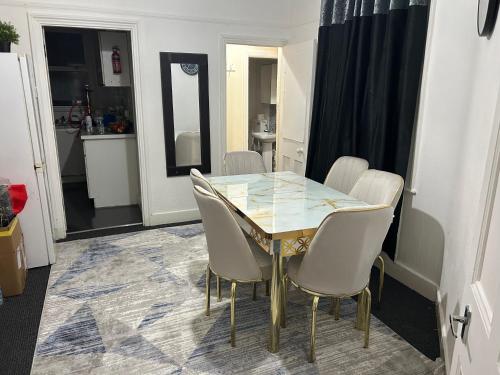 a dining room with a glass table and chairs at House with private garden in London