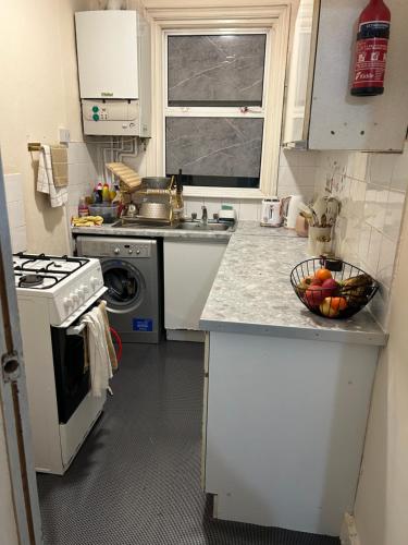 a kitchen with white cabinets and a bowl of fruit on the counter at House with private garden in London