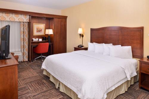 a hotel room with a large bed and a television at Hampton Inn Elkhart in Elkhart