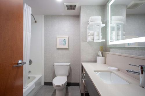 a white bathroom with a toilet and a sink at Hampton Inn Elkins in Elkins