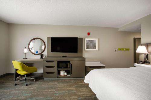 a hotel room with a bed and a desk and a television at Hampton Inn Elkins in Elkins