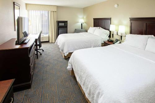 a hotel room with two beds and a desk at Hampton Inn Elizabethtown in Elizabethtown