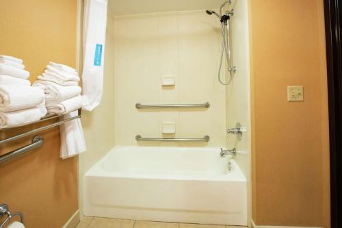 a bathroom with a tub and a shower with towels at Hampton Inn Elizabethtown in Elizabethtown