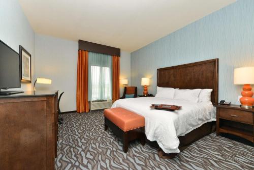 a hotel room with a bed and a flat screen tv at Hampton Inn Corning/Painted Post in Painted Post