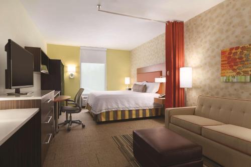 um quarto de hotel com uma cama e um sofá em Home2 Suites by Hilton Erie em Erie