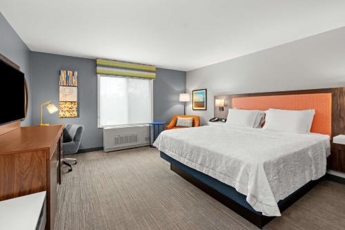 a hotel room with a bed and a flat screen tv at Hampton Inn & Suites Fairbanks in Fairbanks