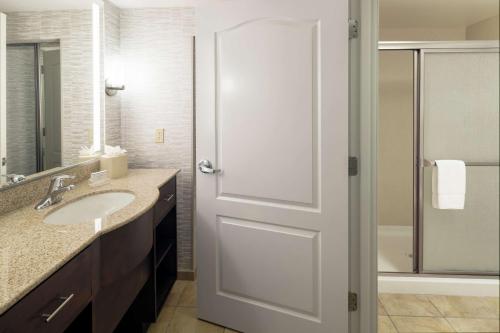 a bathroom with a white door and a sink at Homewood Suites by Hilton Fresno Airport/Clovis in Clovis