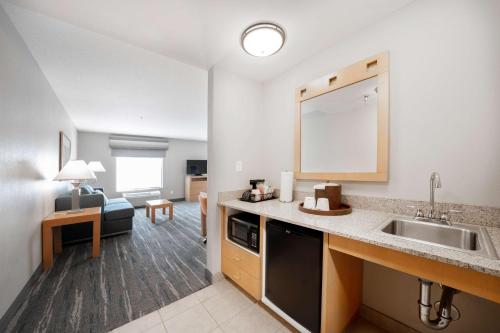 eine Küche mit einem Waschbecken und ein Wohnzimmer in der Unterkunft Hampton Inn & Suites Madera in Madera