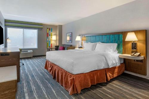 een hotelkamer met een groot bed en een televisie bij Hampton Inn Fort Collins in Fort Collins