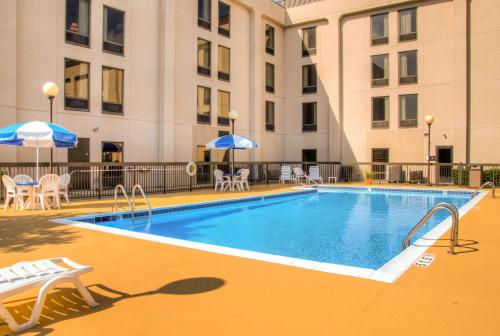 a pool with chairs and umbrellas next to a building at Hampton Inn Frankfort in Frankfort