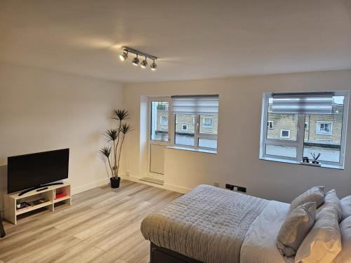 a bedroom with a bed and a flat screen tv at Penthouse Studio by Regent's Park/Euston in London