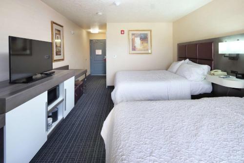 a hotel room with two beds and a flat screen tv at Hampton Inn Sierra Vista in Sierra Vista