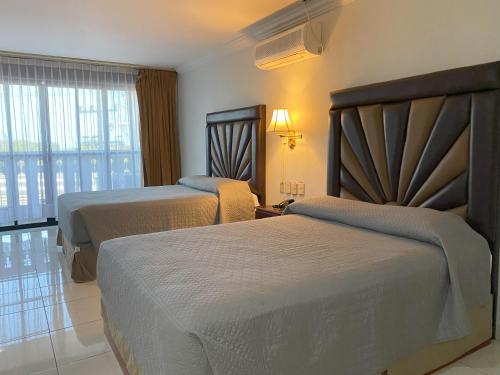 Habitación de hotel con 2 camas y ventana en Grand Royal Tampico, en Tampico