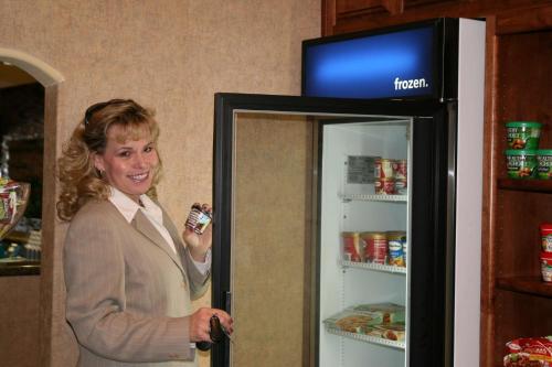 una mujer parada frente a un refrigerador abierto en Hampton Inn & Suites Farmington, en Farmington