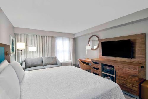 a hotel room with a bed and a flat screen tv at Hampton Inn Ft Lauderdale Airport North Cruise Port in Fort Lauderdale