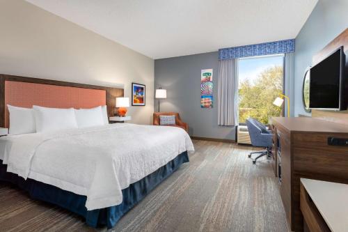 a hotel room with a bed and a television at Hampton Inn Commercial Boulevard-Fort Lauderdale in Tamarac