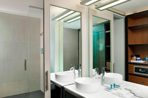 a bathroom with two sinks and a large mirror at Aloft Beachwood in Beachwood