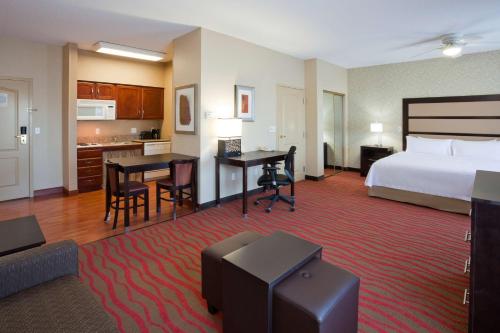 a hotel room with a bed and a kitchen at Homewood Suites by Hilton Sioux Falls in Sioux Falls
