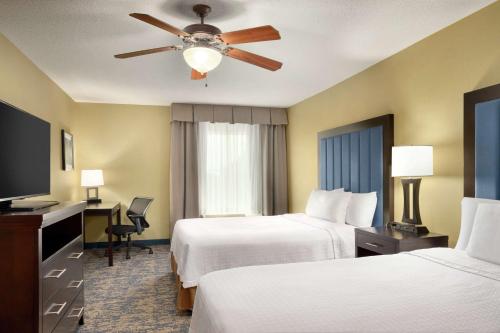 a hotel room with two beds and a ceiling fan at Homewood Suites by Hilton Fort Smith in Massard