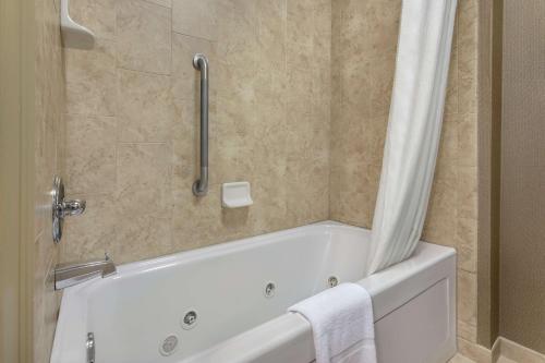 a bathroom with a bath tub with a shower curtain at Homewood Suites by Hilton Fort Smith in Massard