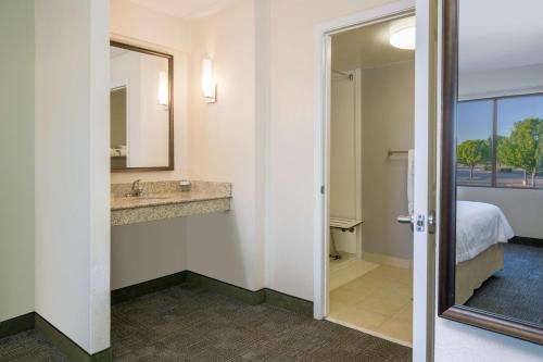 Cette chambre d'hôtel comprend une salle de bains pourvue d'un lavabo et d'un lit. dans l'établissement Homewood Suites by Hilton Ft. Worth-North at Fossil Creek, à Fort Worth